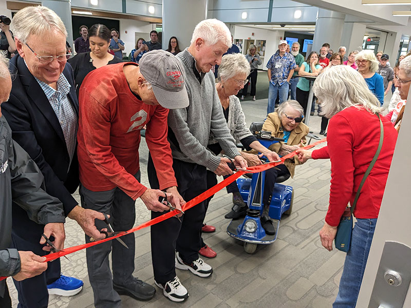 Photo of former schoolmates cutting the ribbon to open the RHS exhibit